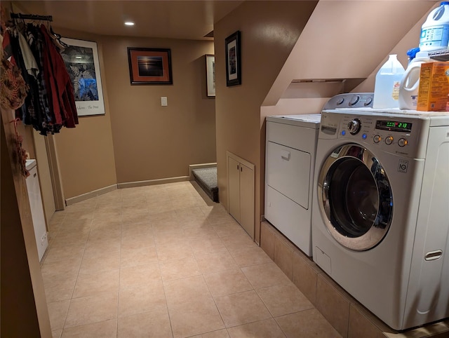 laundry area with light tile patterned floors, laundry area, independent washer and dryer, and baseboards