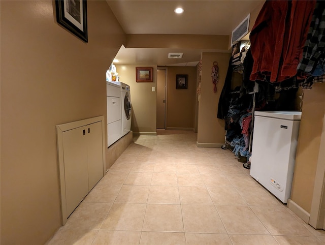 interior space featuring laundry area, light tile patterned floors, visible vents, and washer / dryer