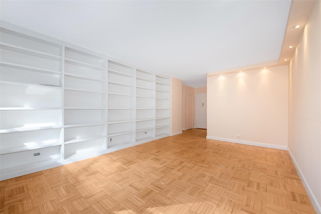 empty room featuring built in shelves and light parquet floors