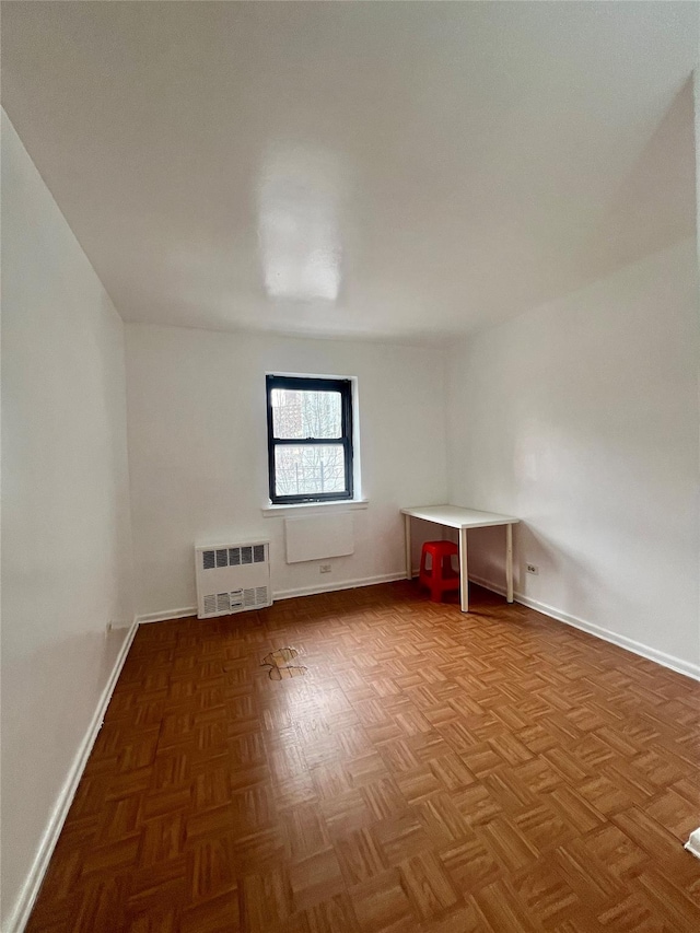 additional living space with parquet flooring and radiator heating unit