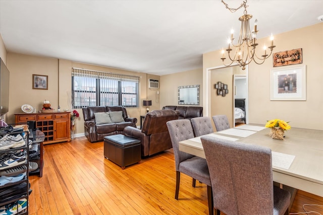 dining area with light hardwood / wood-style flooring, a chandelier, and a wall mounted AC