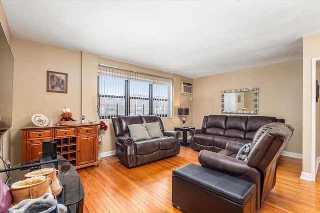 living room featuring a wall unit AC and light hardwood / wood-style floors