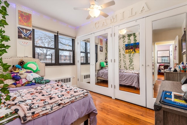 bedroom featuring french doors, ceiling fan, radiator, and light hardwood / wood-style floors