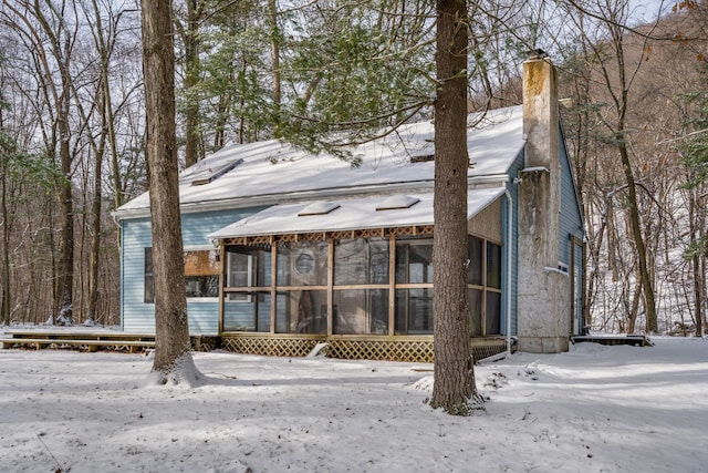 snow covered property with a sunroom