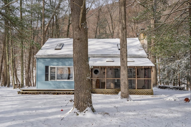 view of snowy exterior featuring a sunroom