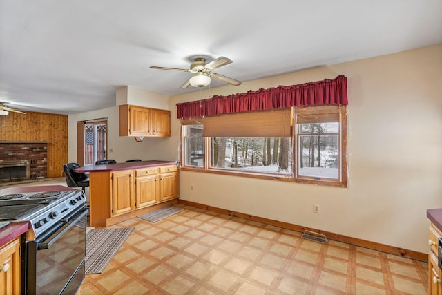 kitchen with electric stove, ceiling fan, and kitchen peninsula