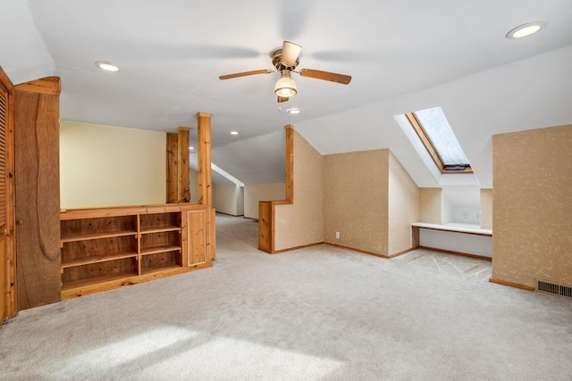 bonus room featuring ceiling fan, lofted ceiling with skylight, and light carpet