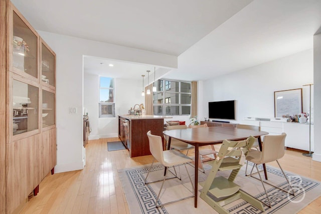 dining space with sink and light hardwood / wood-style floors