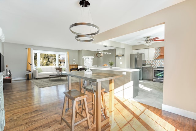 dining room with hardwood / wood-style floors and ceiling fan