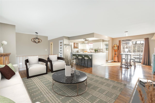 living room with a notable chandelier, plenty of natural light, and light hardwood / wood-style flooring