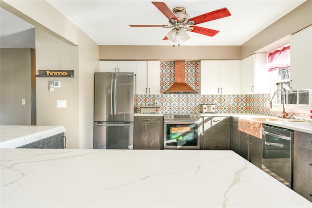 kitchen featuring appliances with stainless steel finishes, white cabinetry, custom range hood, and sink