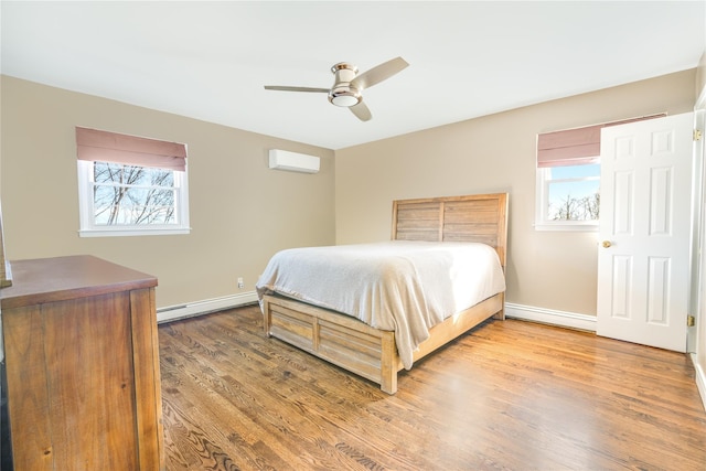 bedroom featuring multiple windows, hardwood / wood-style flooring, an AC wall unit, and baseboard heating