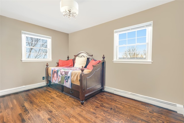 bedroom featuring multiple windows, baseboard heating, and dark hardwood / wood-style flooring