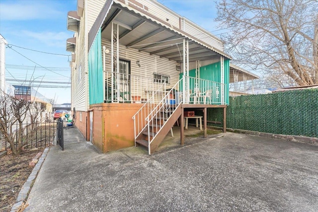 back of property with stairway and fence