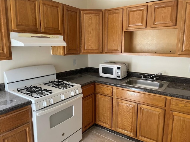 kitchen featuring sink, light tile patterned floors, and white appliances