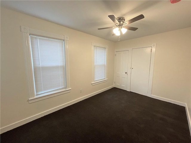 unfurnished bedroom featuring dark colored carpet and ceiling fan