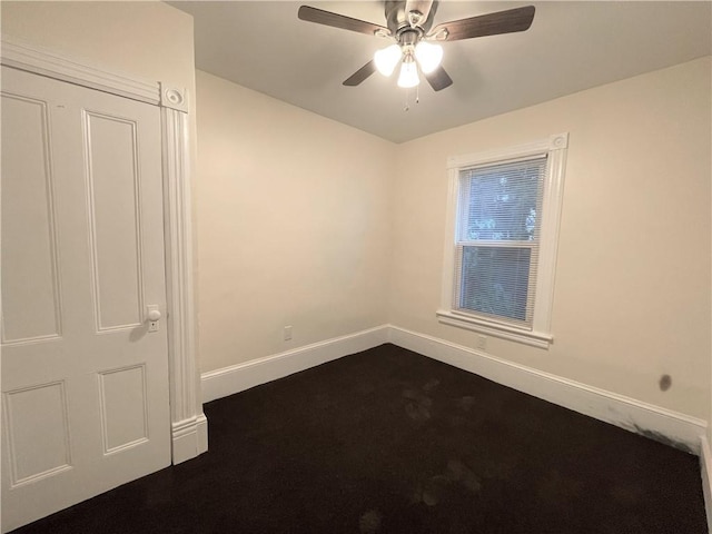 carpeted spare room with ceiling fan