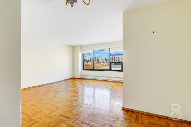 spare room with a baseboard heating unit and light parquet flooring