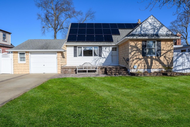 view of front facade with a garage, a front yard, and solar panels