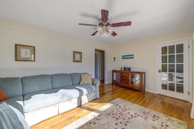 living room featuring ceiling fan and light hardwood / wood-style floors