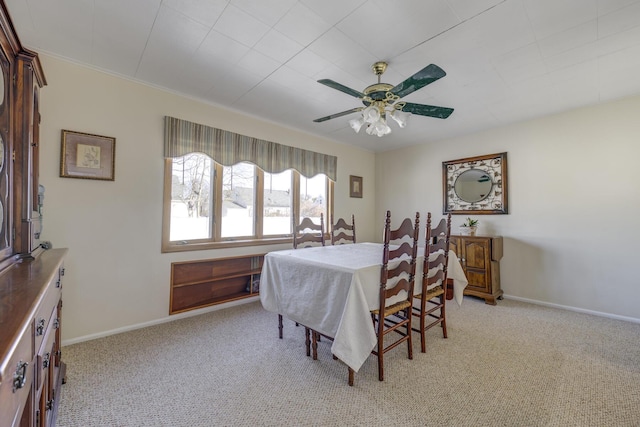 dining space with light colored carpet and ceiling fan