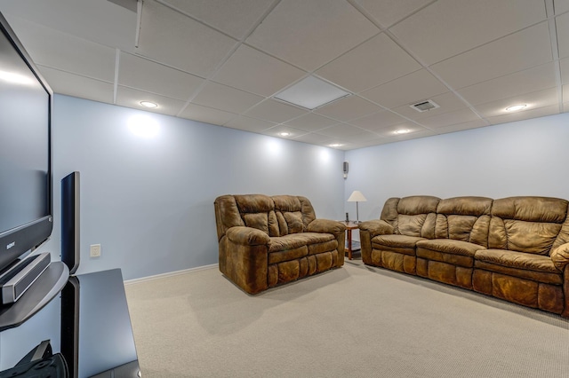 carpeted living room featuring a drop ceiling