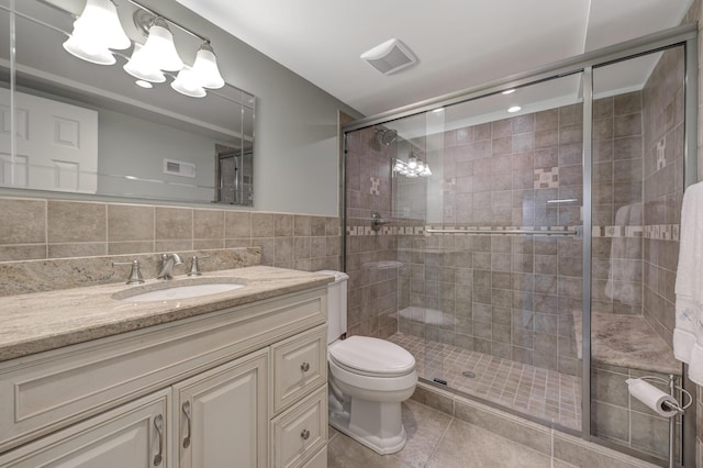 bathroom featuring tile walls, tile patterned flooring, an enclosed shower, vanity, and toilet