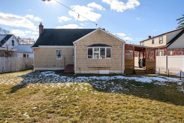 rear view of property featuring a lawn