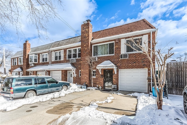 townhome / multi-family property with a garage, brick siding, fence, and a chimney