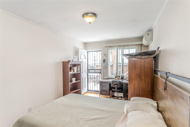 bedroom featuring ornamental molding, a wall unit AC, light hardwood / wood-style floors, and access to outside