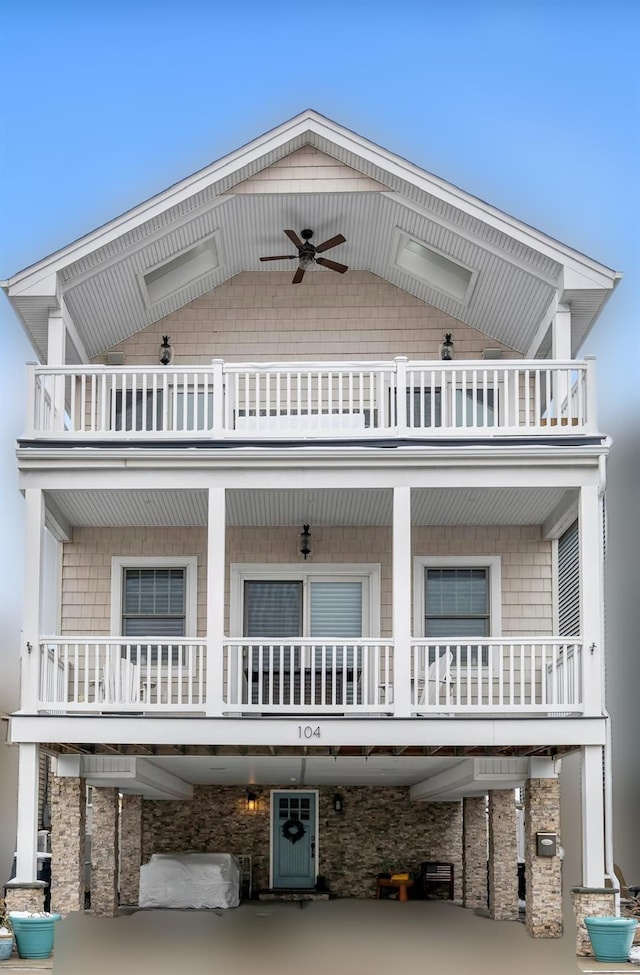 view of front of home with ceiling fan and a balcony