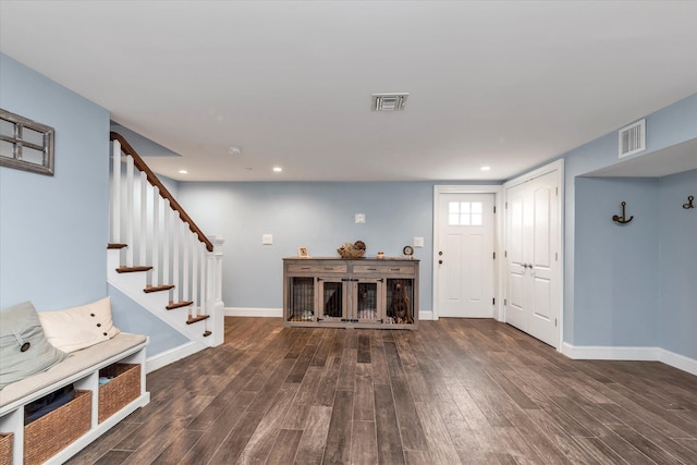 foyer featuring dark wood-style floors, stairway, visible vents, and baseboards