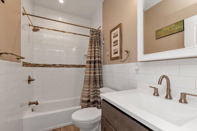 bathroom featuring toilet, shower / tub combo, wainscoting, and vanity