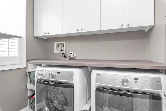 clothes washing area with cabinet space and washer and clothes dryer