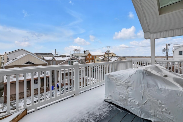 snow covered deck featuring a residential view