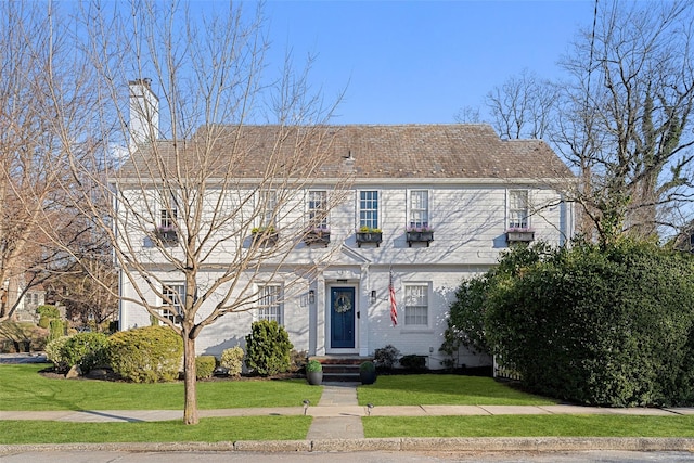 view of front of property featuring brick siding and a front lawn