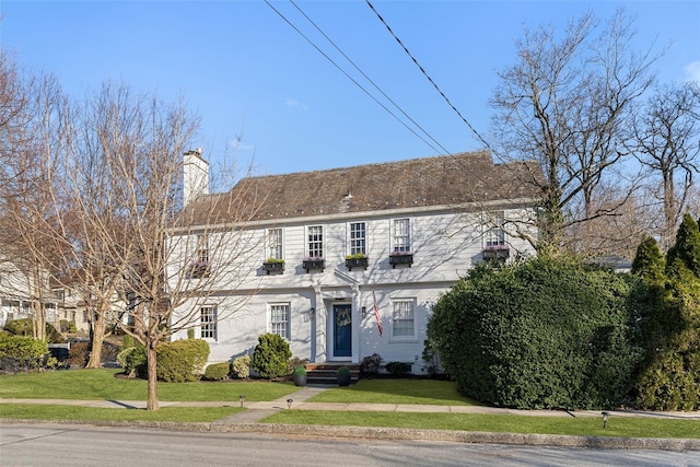 view of front of home featuring a front lawn and a chimney