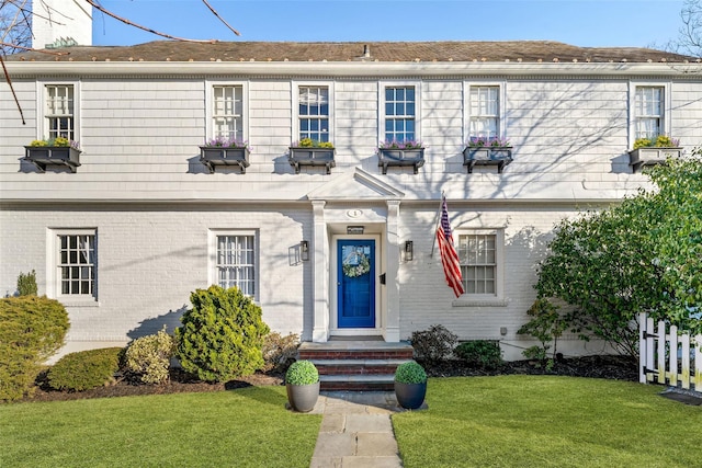 view of front of house featuring brick siding and a front lawn