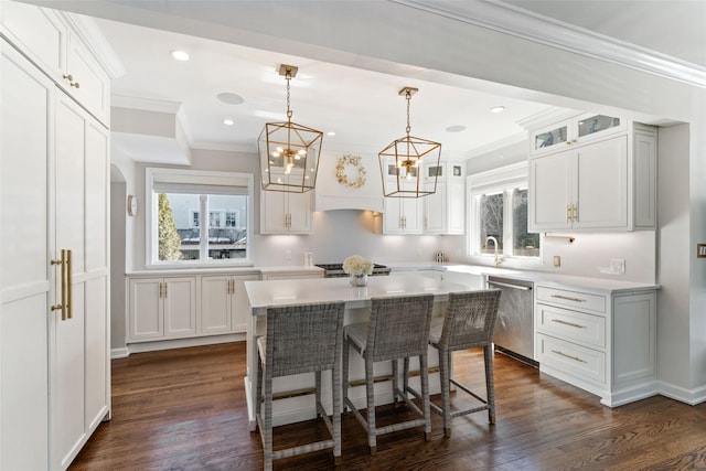 kitchen featuring arched walkways, a breakfast bar area, stainless steel dishwasher, white cabinetry, and premium range hood