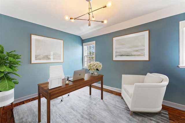 office space featuring baseboards, wood finished floors, and a notable chandelier