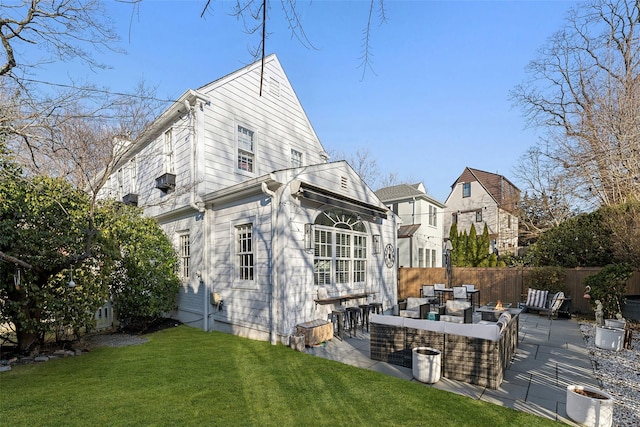 back of property with a patio area, outdoor lounge area, a yard, and fence