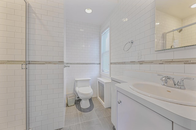 182-61 Avon Rd, Jamaica Estates, NY 11432 - bathroom with tile patterned floors, toilet, tile walls, vanity, and a shower with door