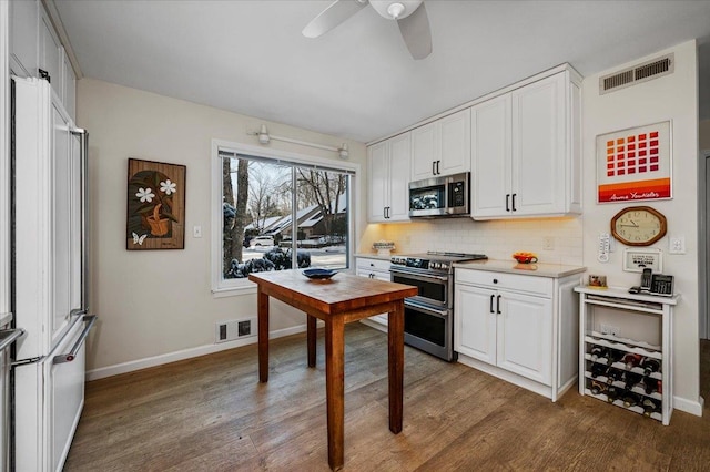 kitchen with white cabinets, visible vents, appliances with stainless steel finishes, and light countertops