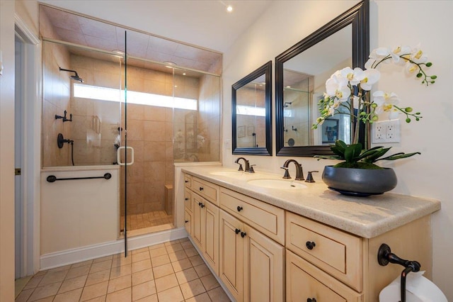 full bath with double vanity, a sink, a shower stall, and tile patterned floors