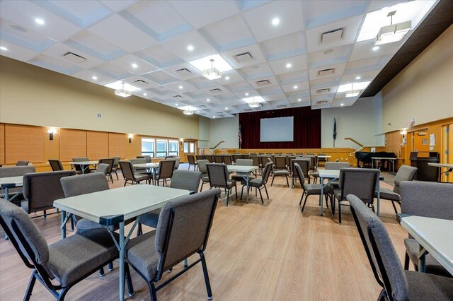 dining room with visible vents, light wood-type flooring, and a towering ceiling