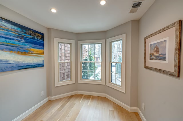 spare room with light wood finished floors, baseboards, visible vents, and recessed lighting