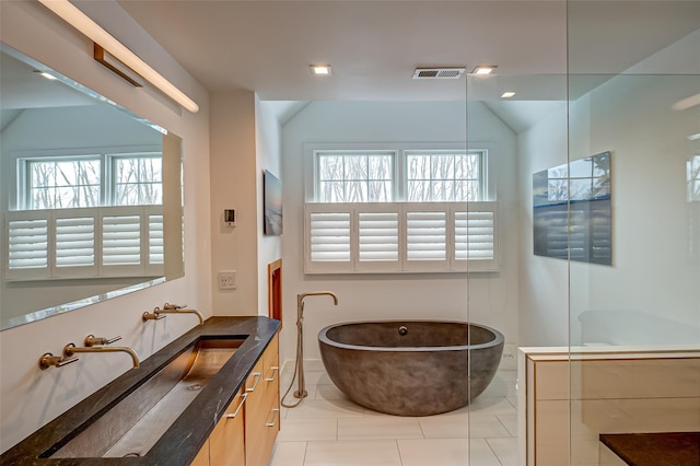 full bath featuring a freestanding bath, visible vents, vanity, and a wealth of natural light