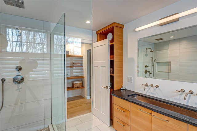 full bathroom with visible vents, a tile shower, vanity, and tile patterned floors