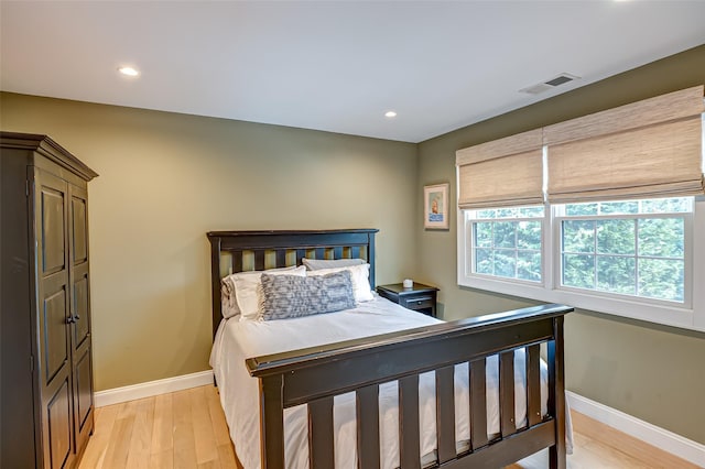 bedroom featuring light wood-type flooring, visible vents, baseboards, and recessed lighting