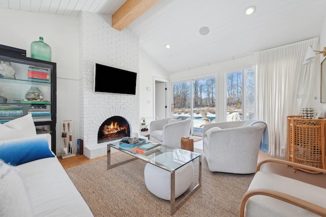 living room featuring lofted ceiling with beams, light wood-style floors, a fireplace, and recessed lighting